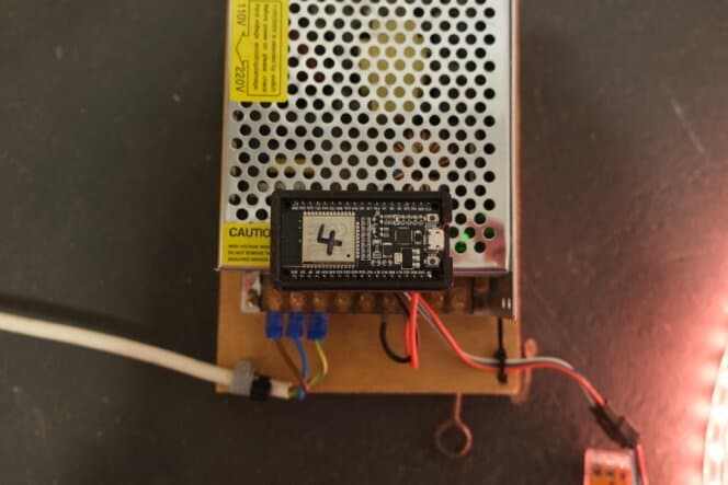 ESP8266 und Netzteil auf der Trägerplatte, daneben der leuchtende Streifen